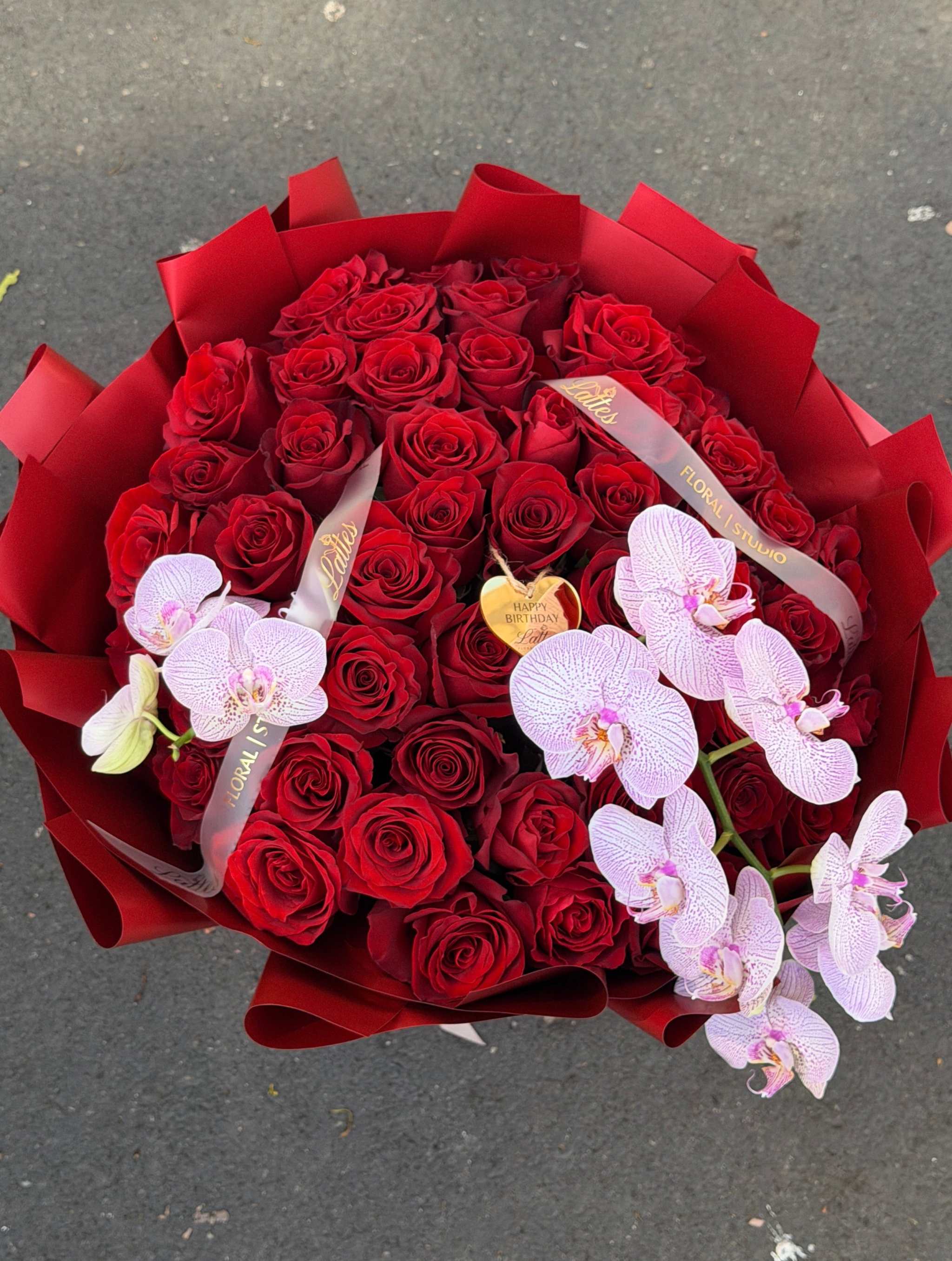 Luxurious bouquet of red roses and orchids for romantic flower delivery