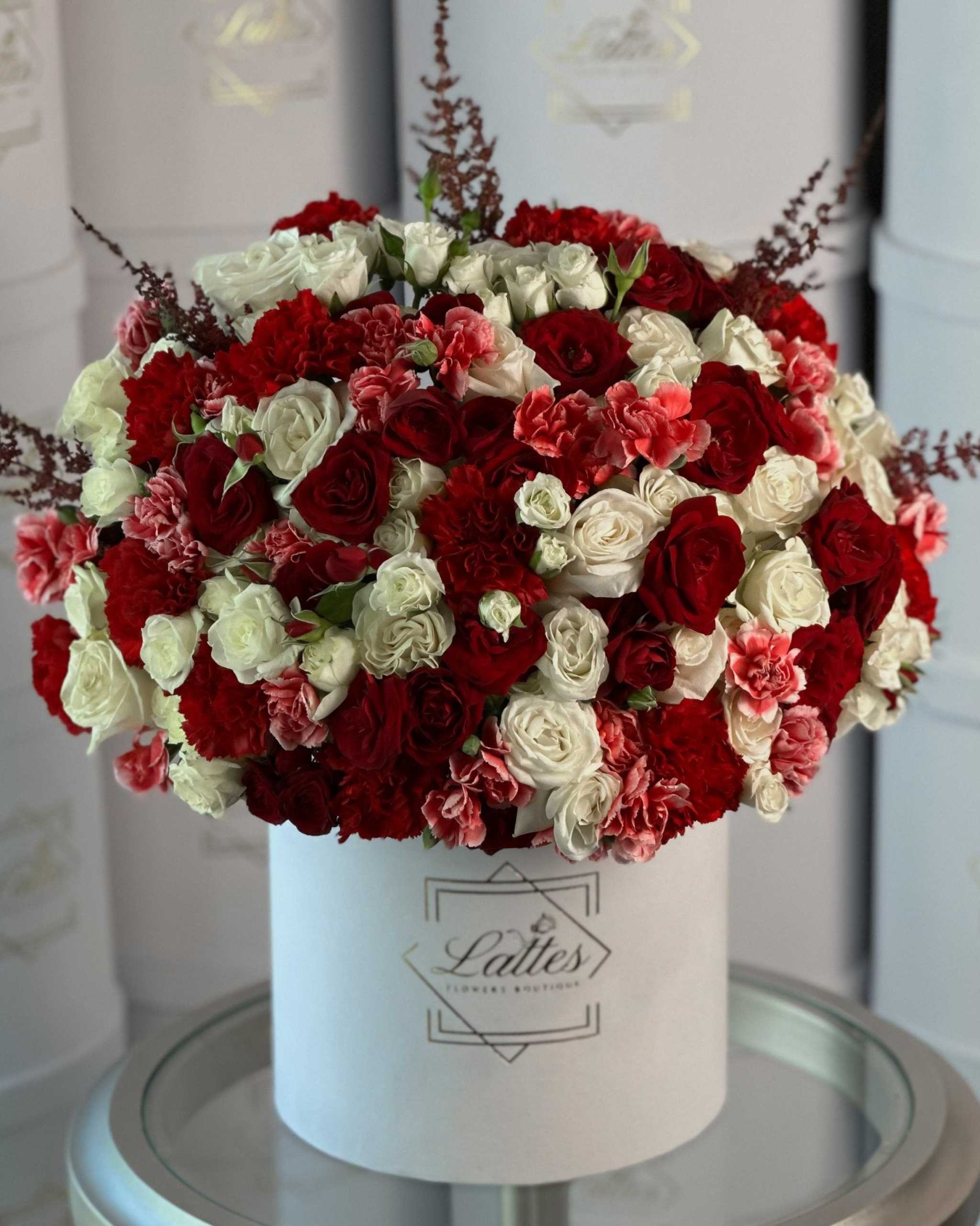 Incanto Fiorito floral arrangement with red and white roses, carnations, and tall astilbe stems