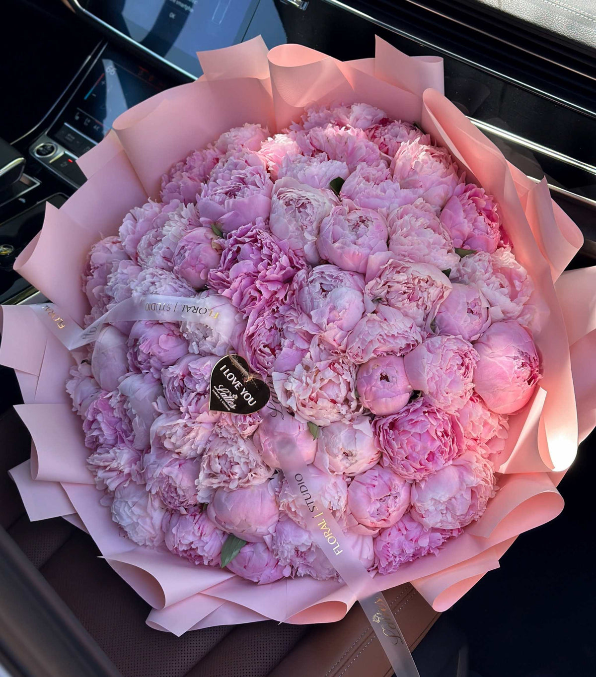 Velvet Passion bouquet with deep burgundy peonies, dusty miller foliage, and amaranth accents wrapped in creamy paper