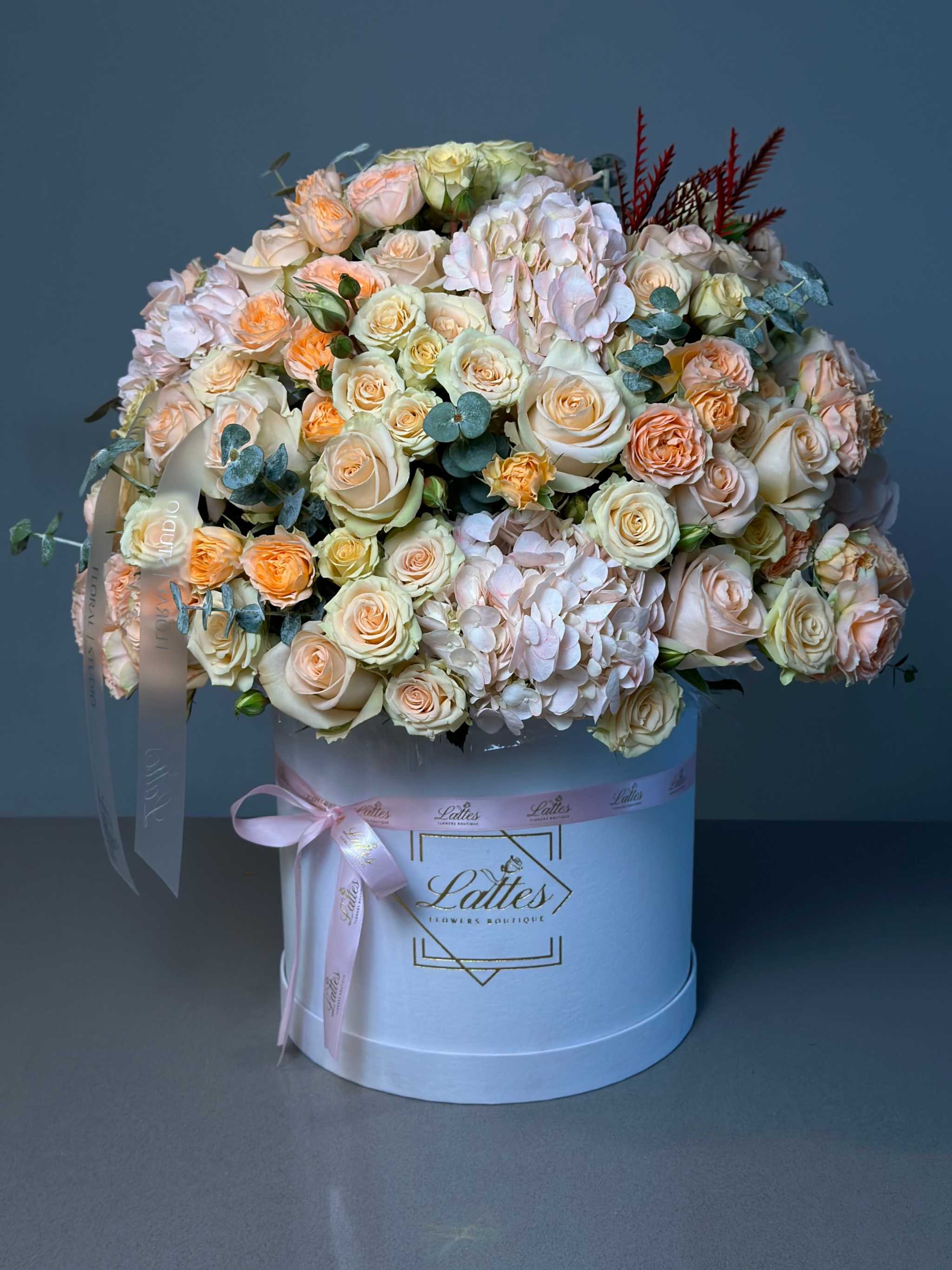 Peach Serenade floral arrangement with peach and white roses in a white hat box