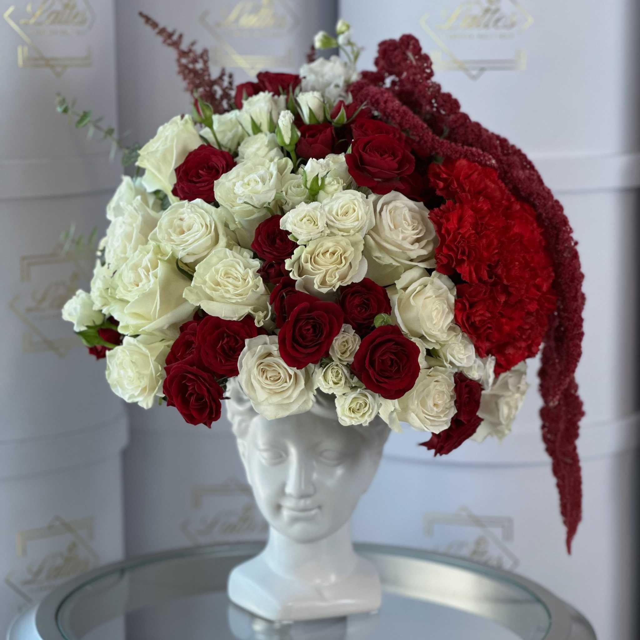 Luce di Luna luxury floral arrangement with red cream roses cascading amaranthus and unique vase