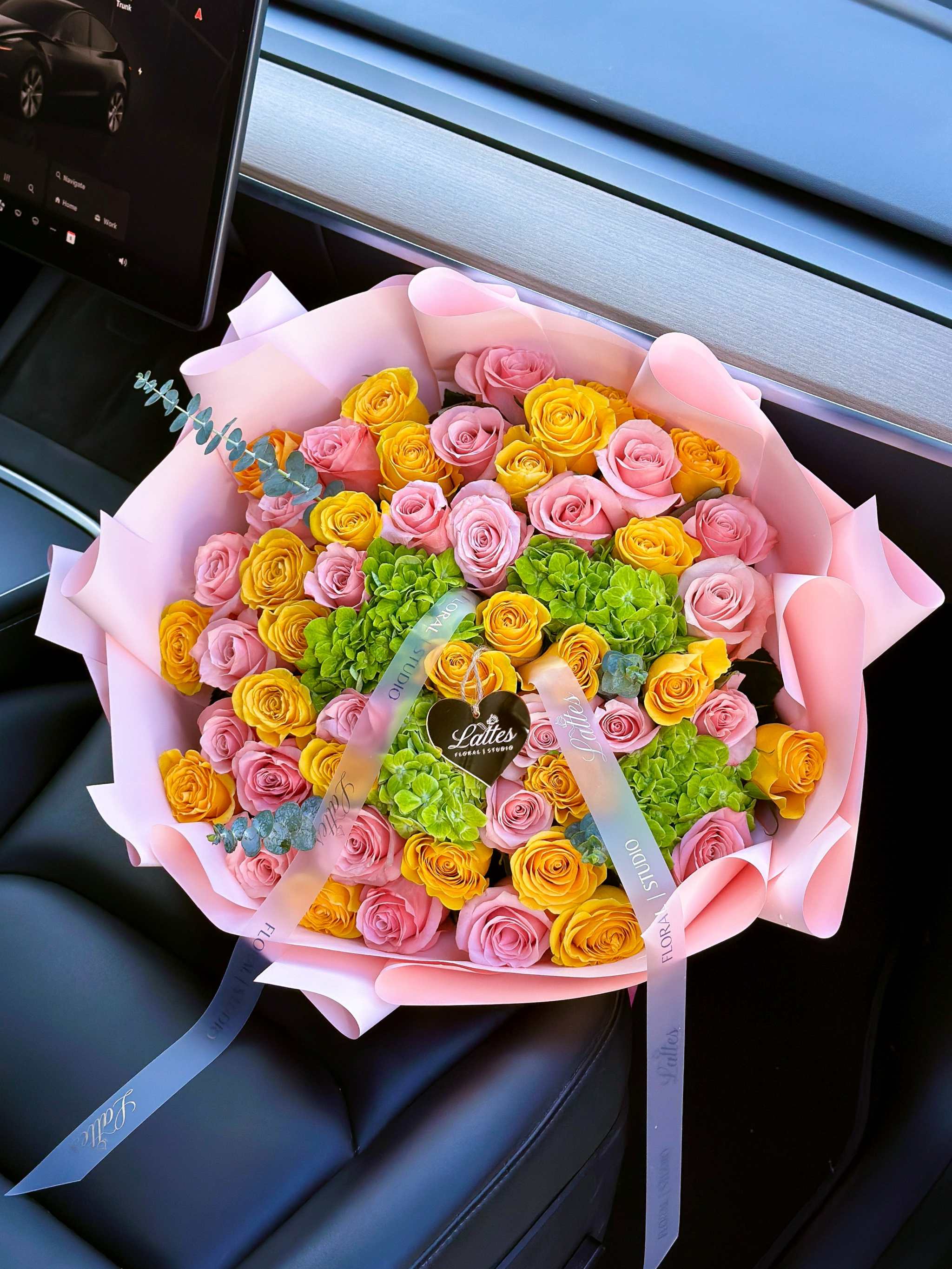 Lumiere de Provence bouquet with yellow and pink roses and green hydrangeas wrapped in pastel paper