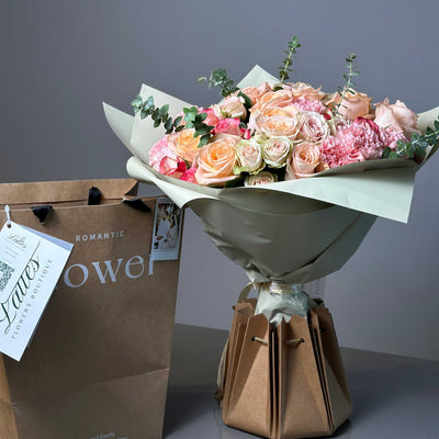 Romantic blush bouquet with pink roses and eucalyptus leaves in elegant wrapping
