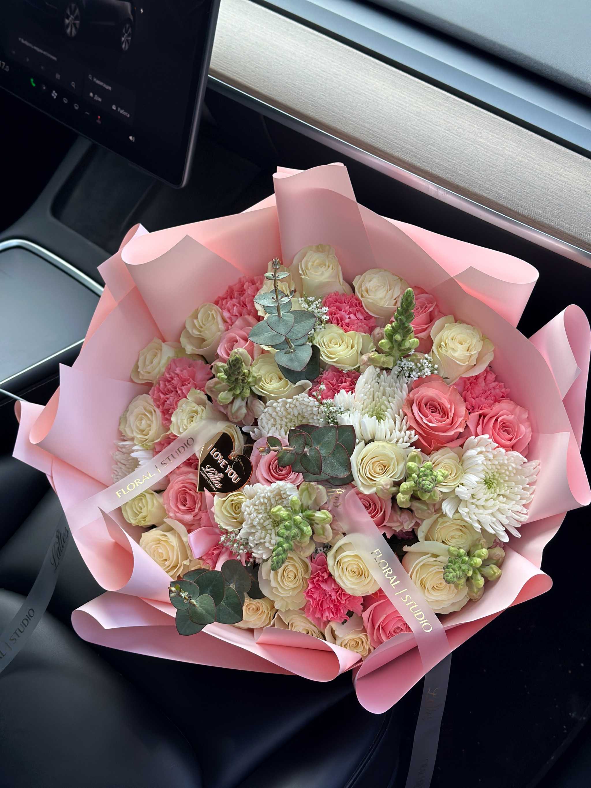 Sweet Bloom bouquet with cream roses, pink carnations, white chrysanthemums, eucalyptus, and pastel pink wrapping