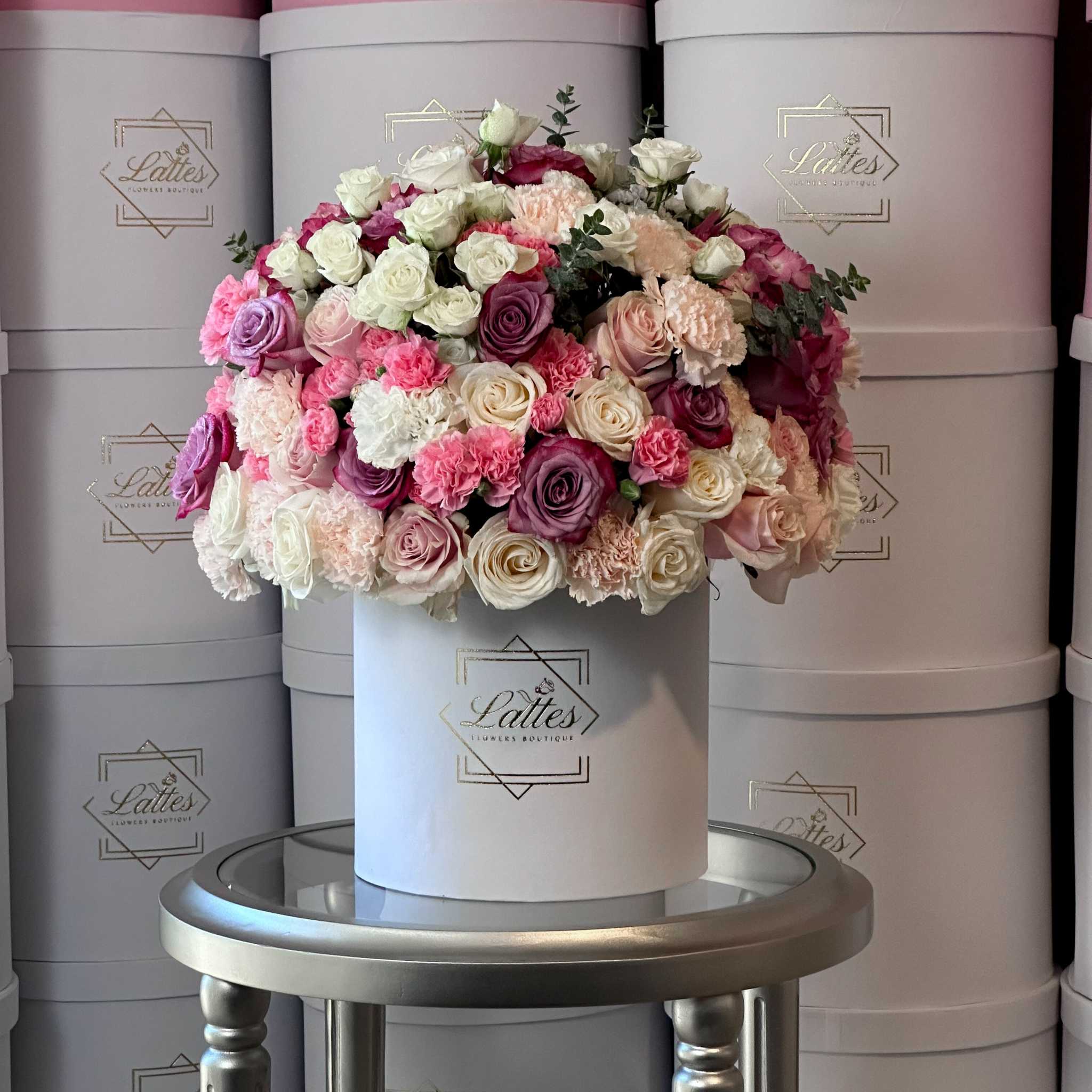Love Chanson floral arrangement with white and purple roses, eucalyptus, and carnations in an elegant flower box