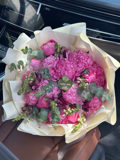 Wild Peony Garden bouquet with lush fuchsia pink peonies and greenery in ivory wrapping