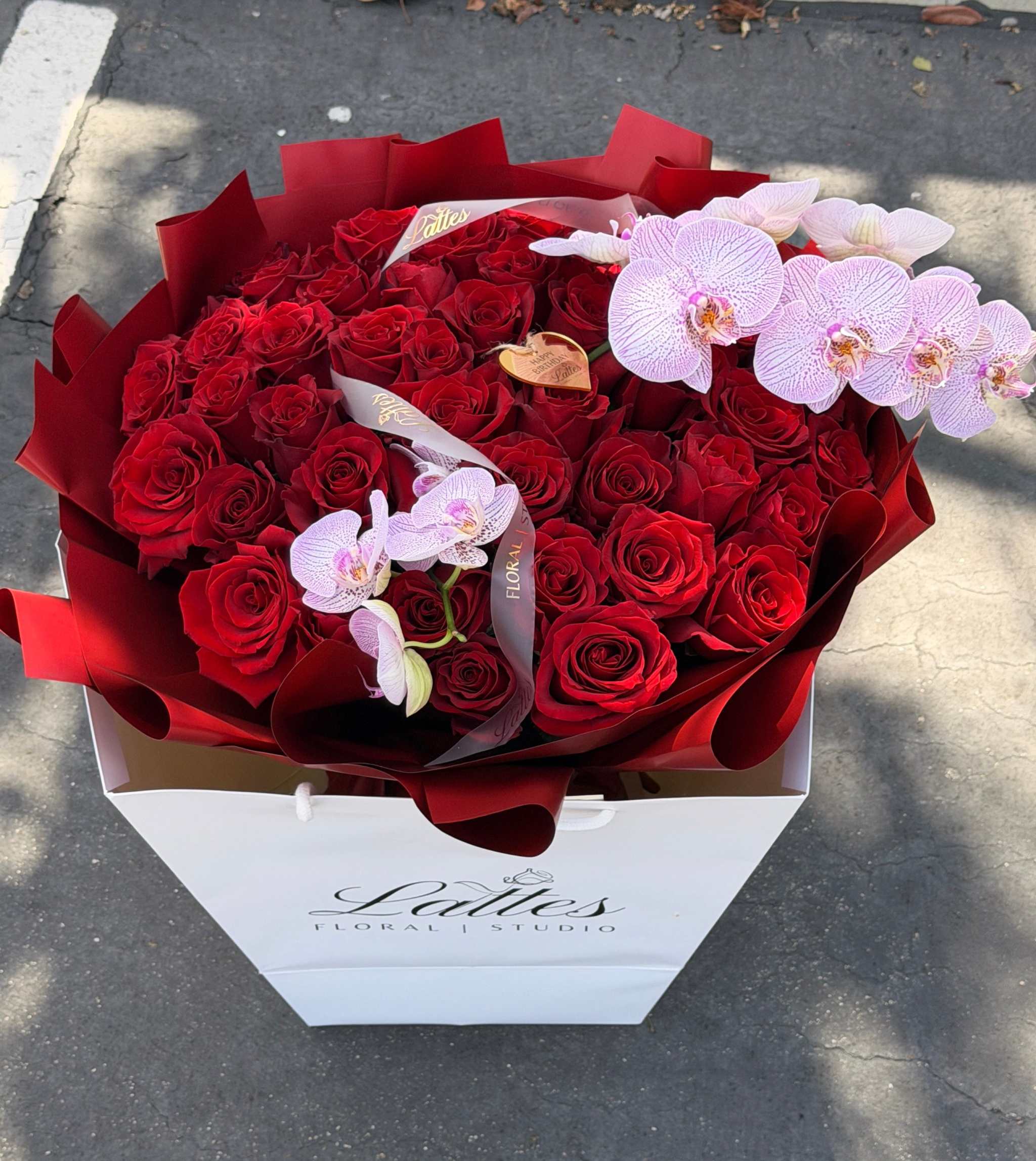 Bouquet of red roses and orchids with elegant wrapping for flower delivery