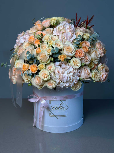 Peach Serenade floral arrangement with peach and white roses in a white hat box