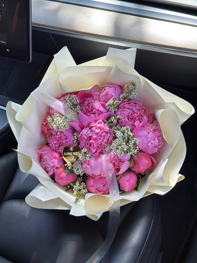 Pink Peony Crush bouquet with lush fuchsia peonies and white filler blooms wrapped in ivory paper