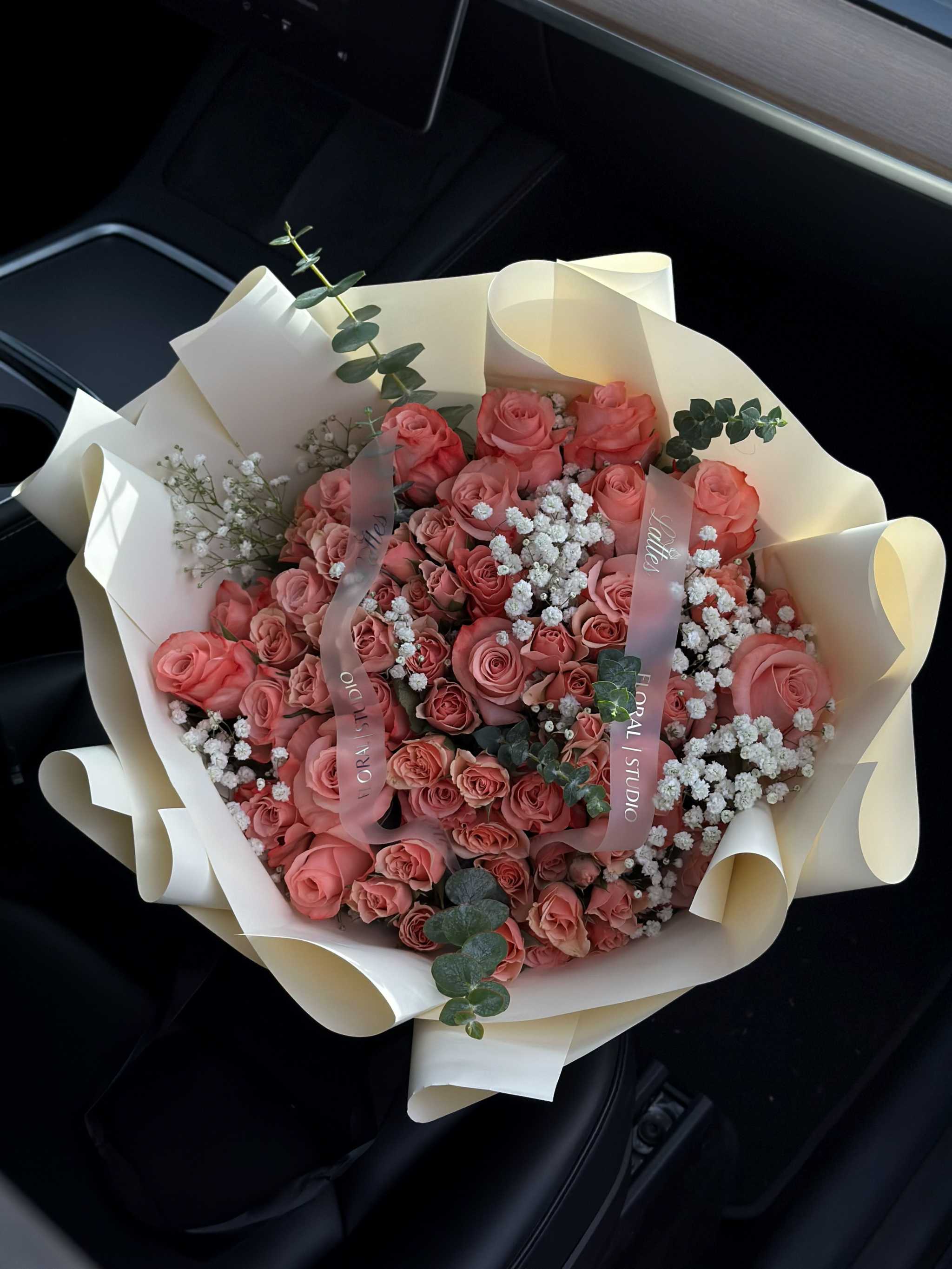 Dusty pink roses bouquet with spray roses, baby's breath, and eucalyptus wrapped in ivory paper